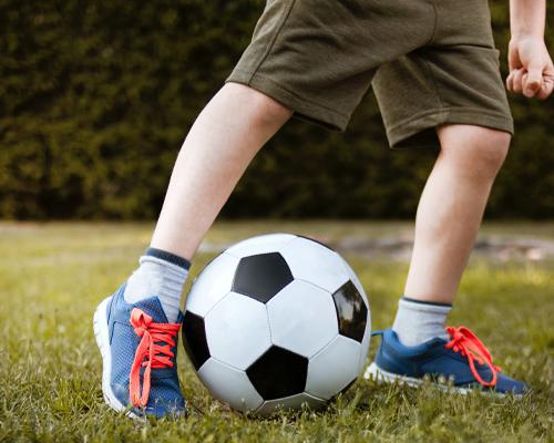 Un niño jugando fútbol con calzado nuevo